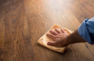Bild von putzender Hand auf Parkettboden